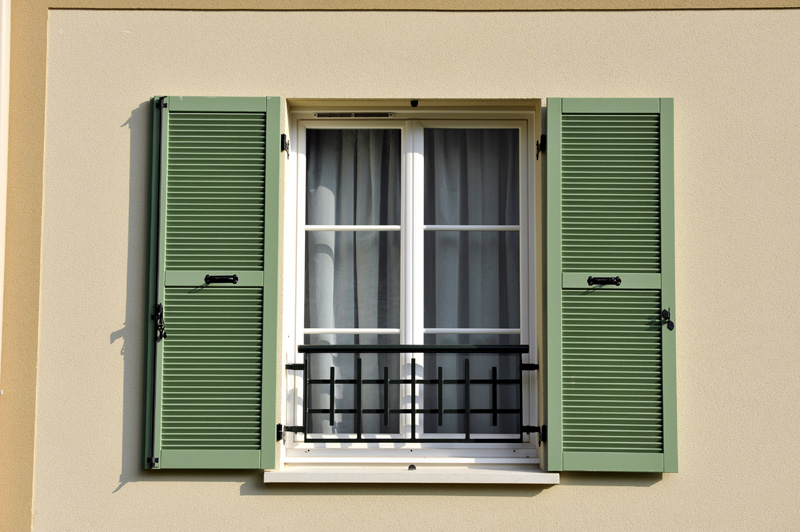 Fenêtre avec des volets battants verts
